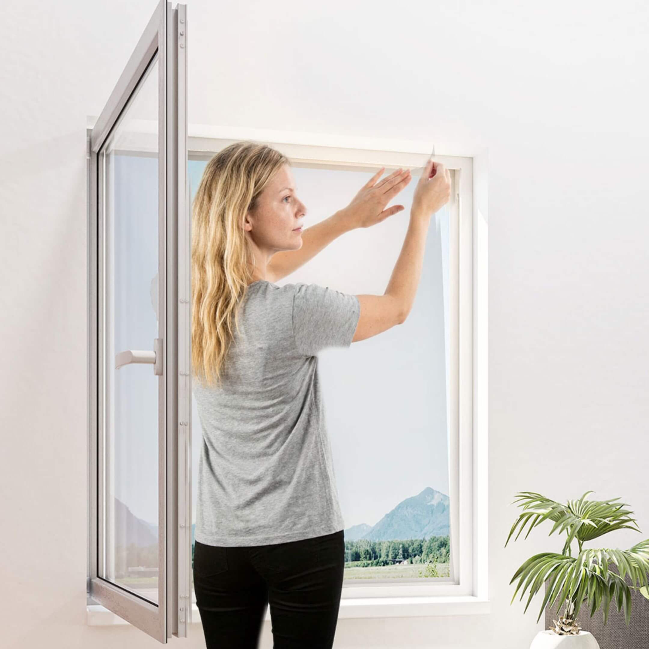Fliegengitter mit Klettband für Fenster selbstklebend in Weiß an einem geöffneten Fenster